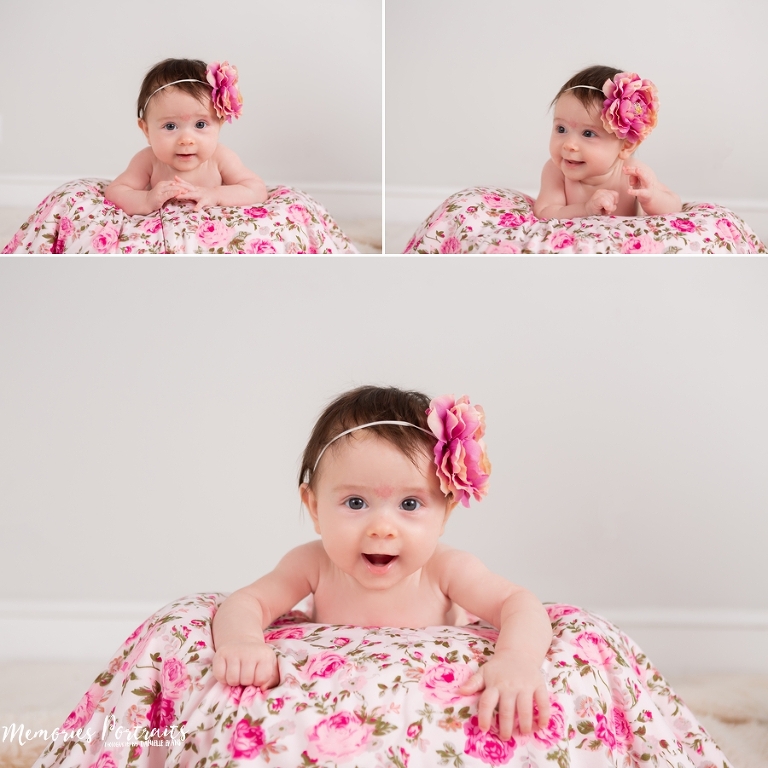 3 month old baby girl sitting up on pink floral blanket