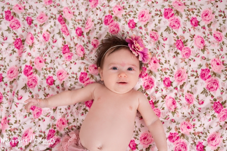 over the top shot of 3 month old newborn laying on pink floral blanket