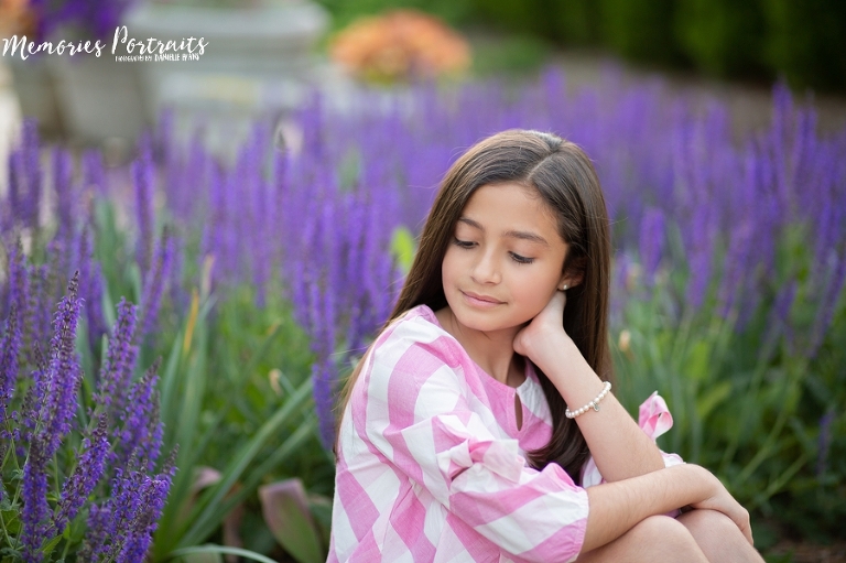 brunette girl in front of purple flowers